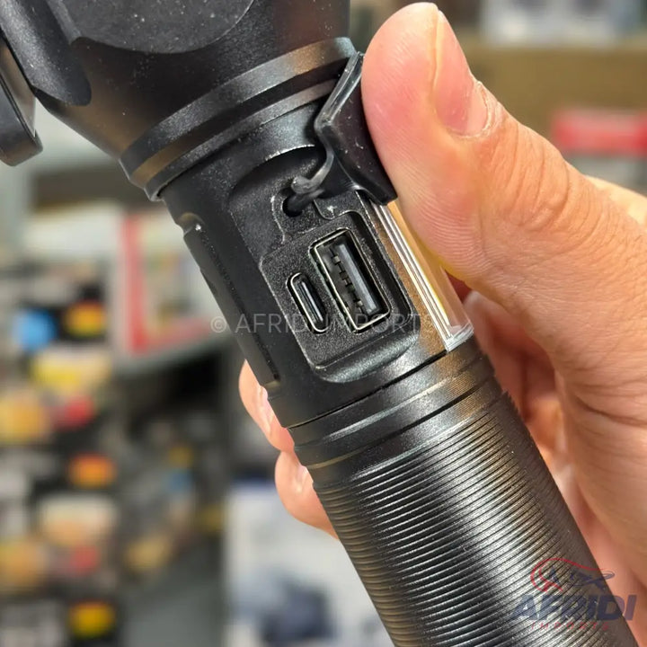 A black flashlight with a USB-A and USB-C port, designed for charging other devices and its own power.