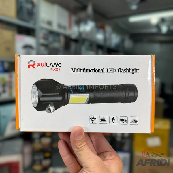 Black multifunctional LED flashlight in its retail packaging.