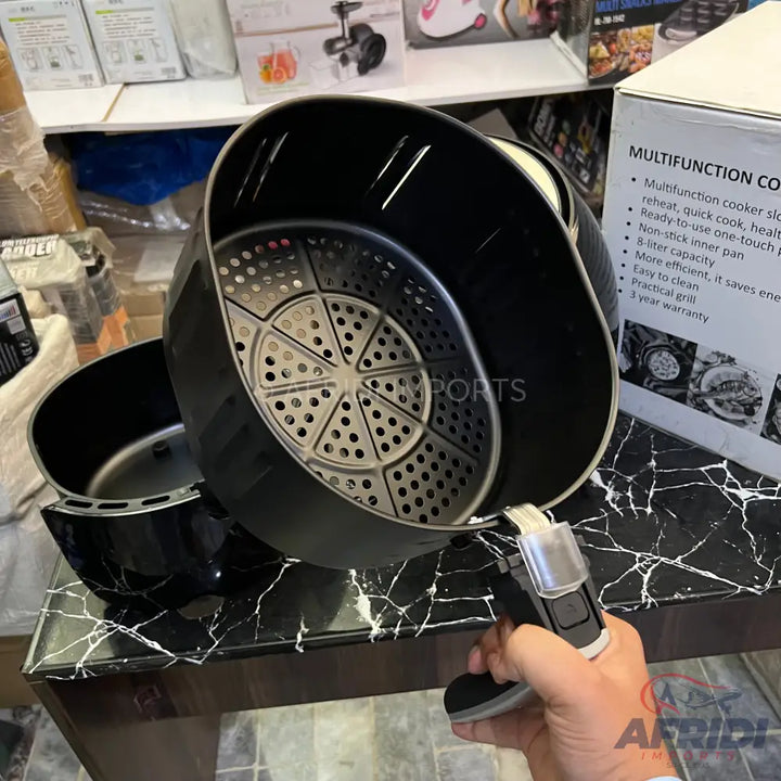 Black air fryer with a removable basket and handle.