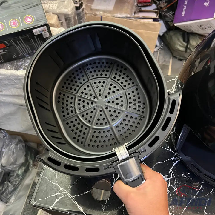 Black air fryer basket with a removable perforated insert.