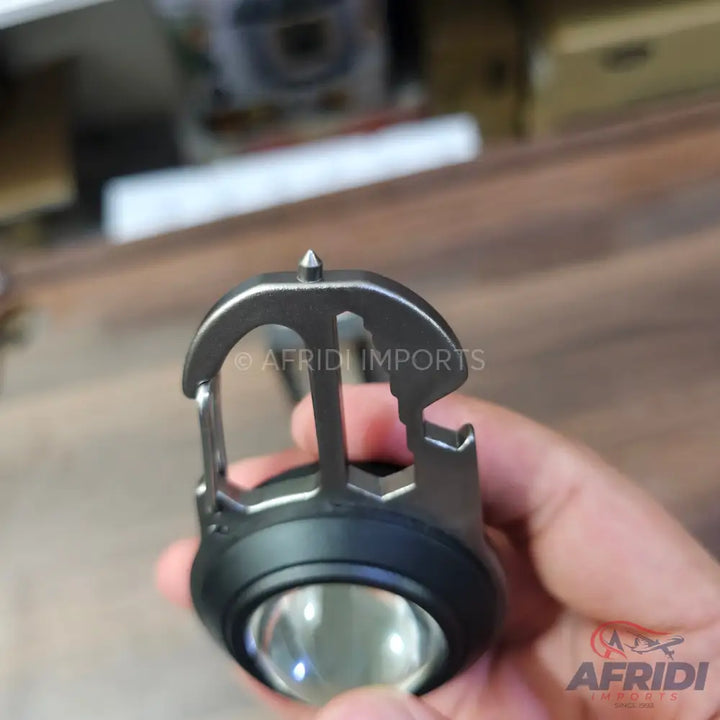 Multi-tool keychain with a flashlight, bottle opener, and pointed tip.