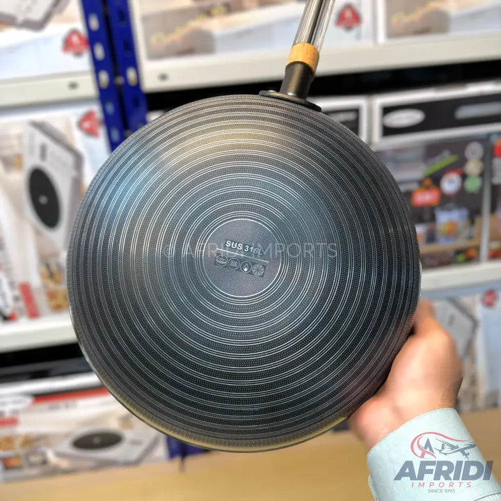 A dark-colored non-stick frying pan with a textured, ridged bottom, suitable for various cooking applications.