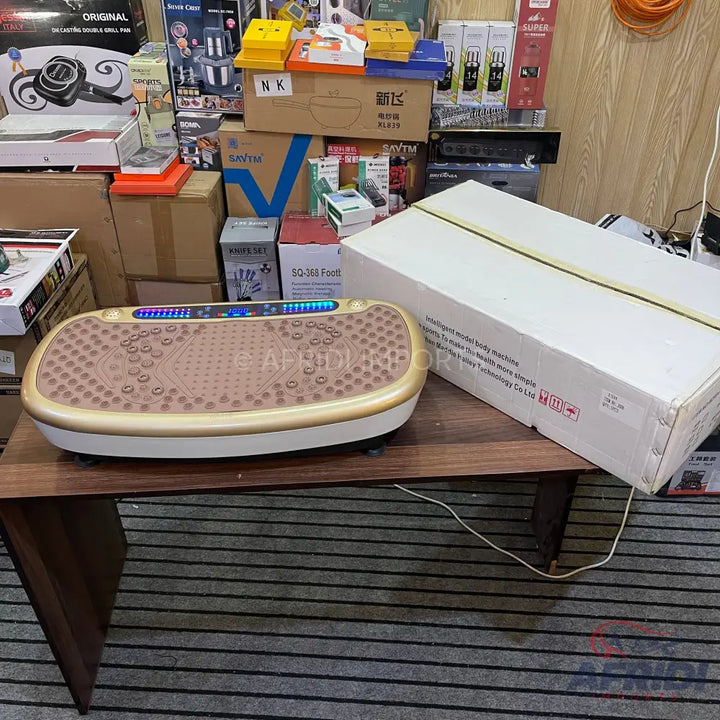 A gold and white vibrating exercise platform with a textured surface and blue LED display.