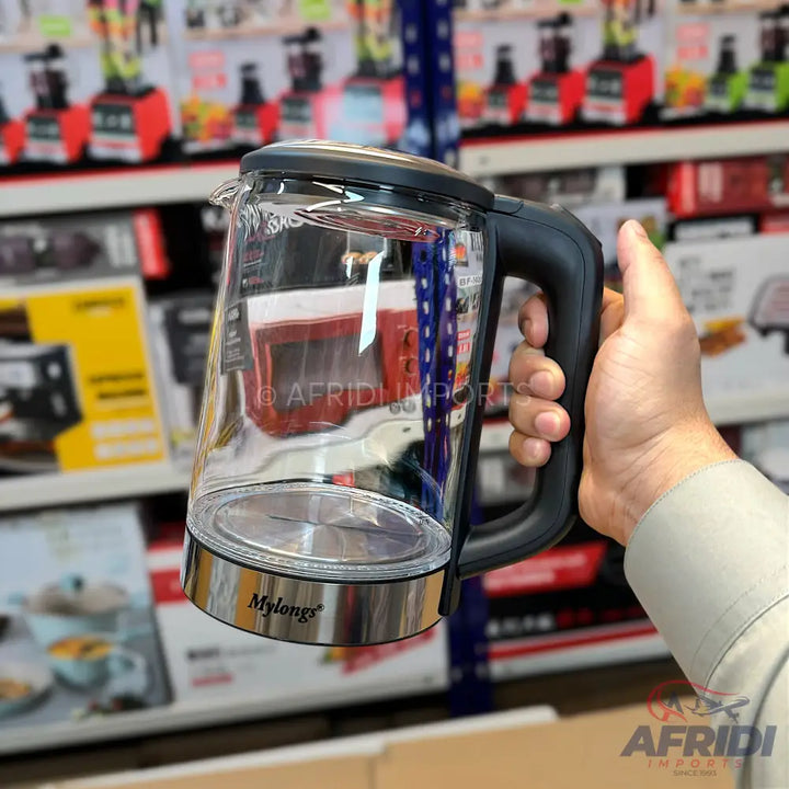 Clear glass electric kettle with a black handle and a chrome base.