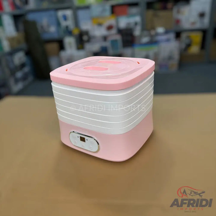 Pink and white portable, multi-tiered electric food steamer with a digital display.