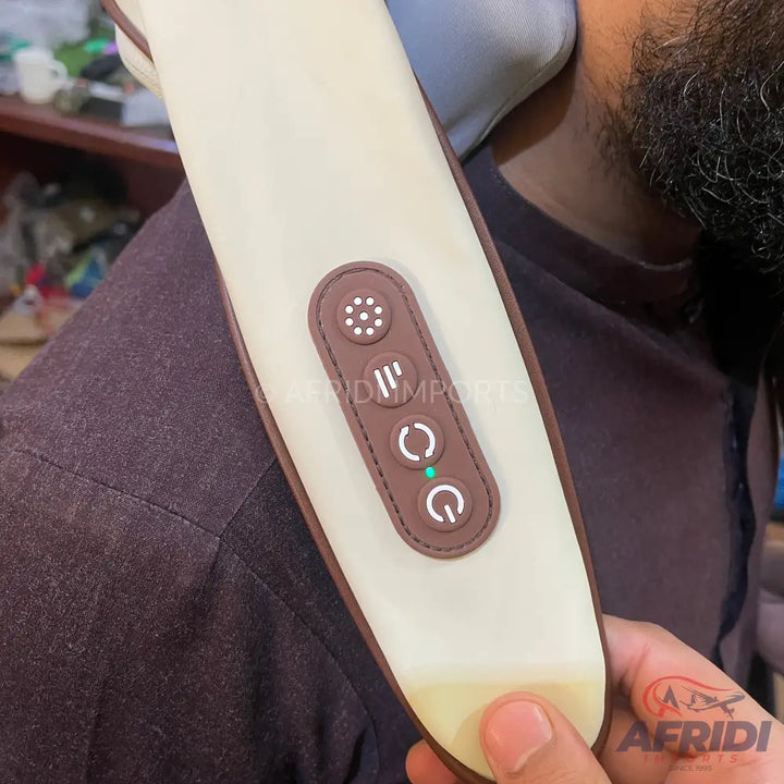 A cream and brown portable electric massager with control buttons.