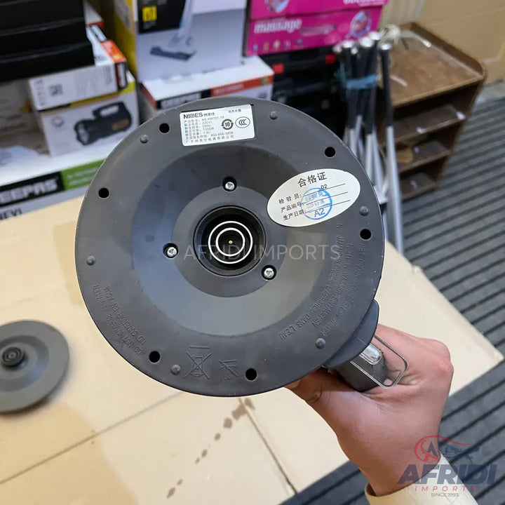 The underside of a dark gray electric kettle base with a central power connector.