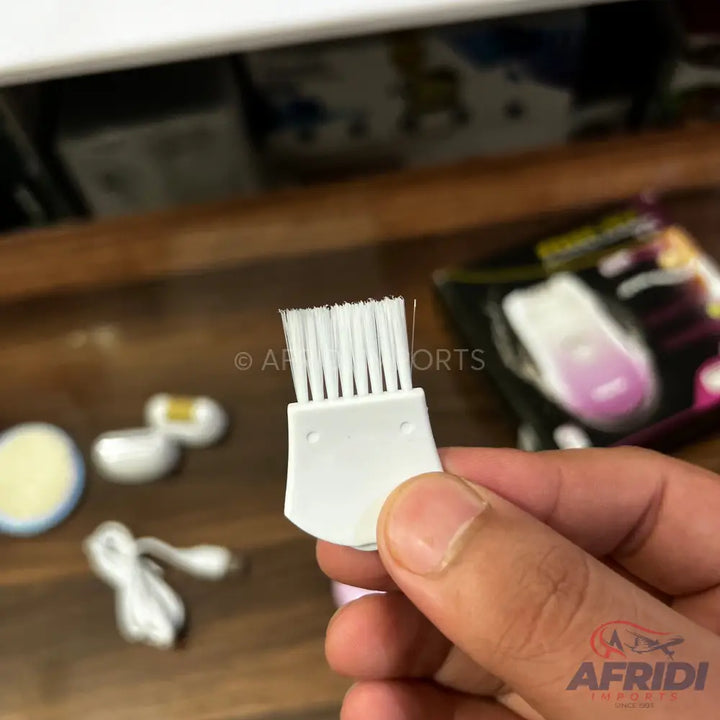 A small white cleaning brush with short bristles, designed for a beauty or grooming device.