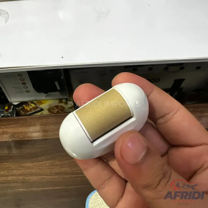 A compact, white, pill-shaped lint roller with a golden-brown adhesive surface.