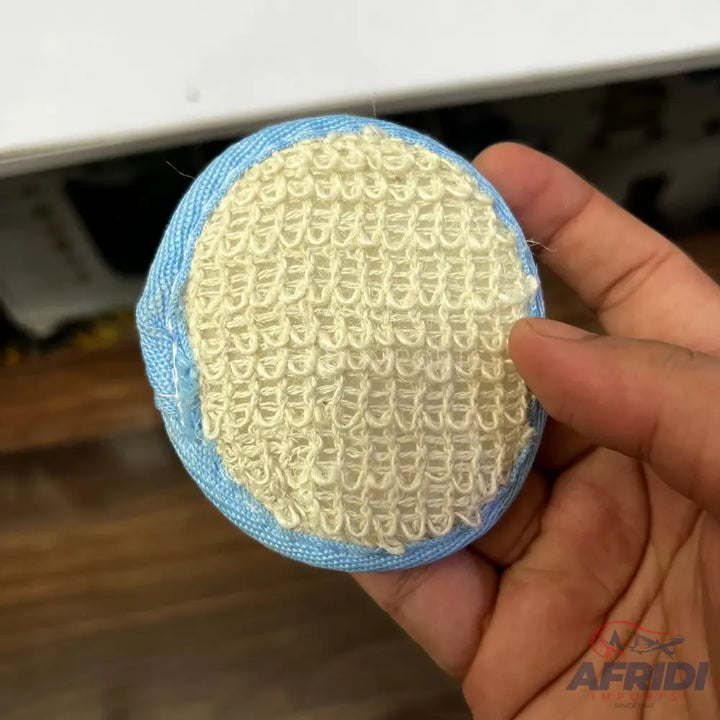 A round, blue-edged laundry ball with a textured, light-colored surface.