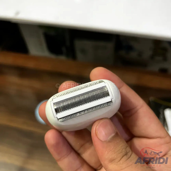 White electric shaver head with a foil and two trimmers.