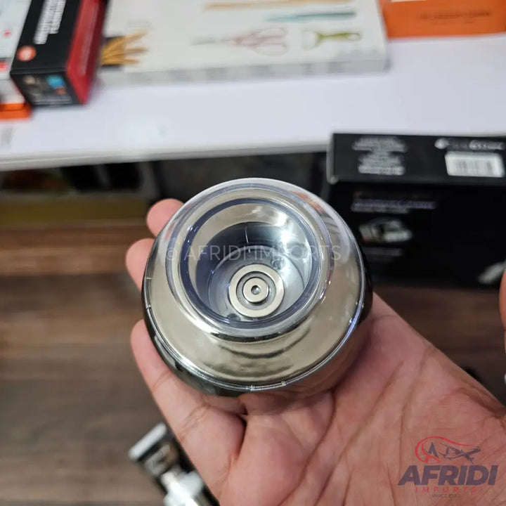 A handheld, shiny, metallic, and clear plastic automatic bottle opener.