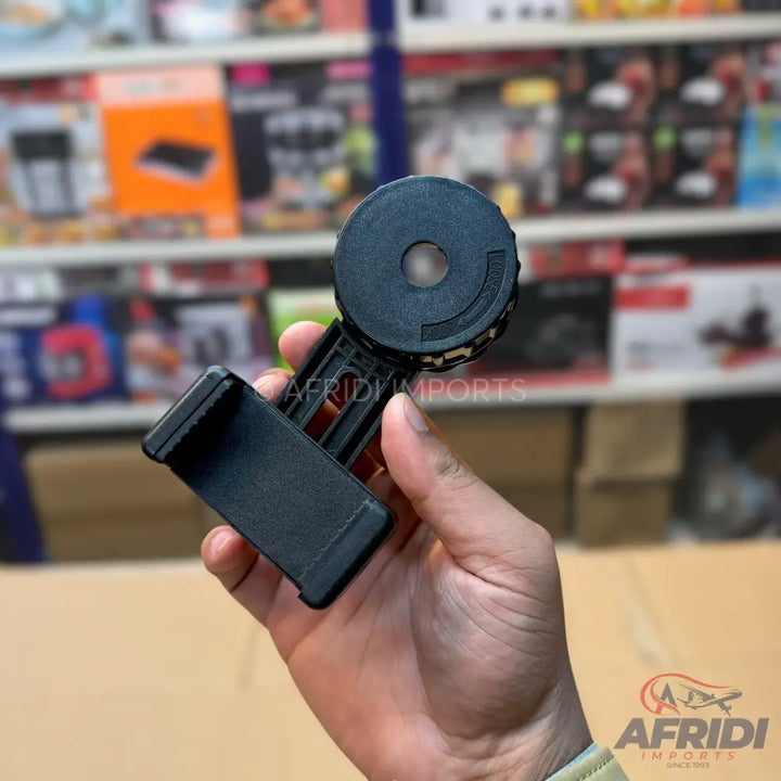 Black plastic phone holder with a circular lens attachment.