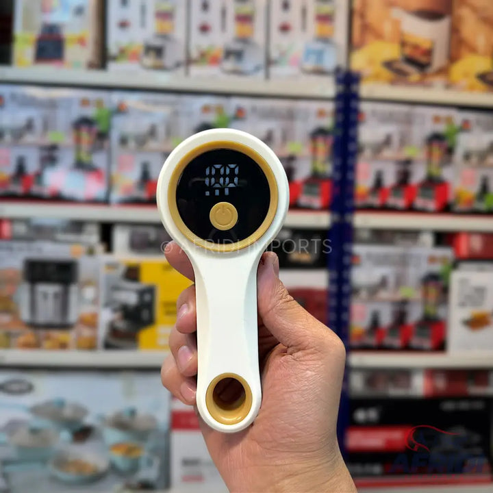White and gold handheld digital display device with a button.