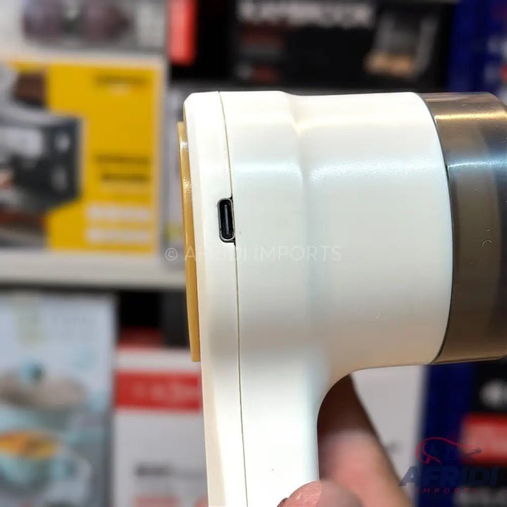 White handheld fabric shaver with a USB-C charging port.