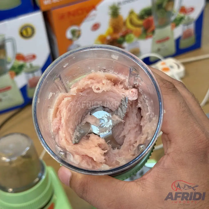 A food processor with raw meat being ground.