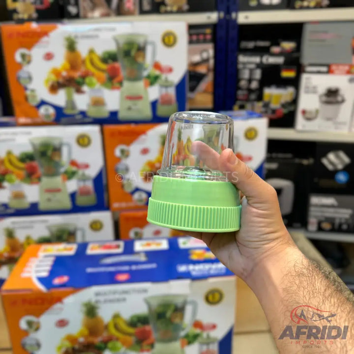 A transparent blender cup with a light green base.