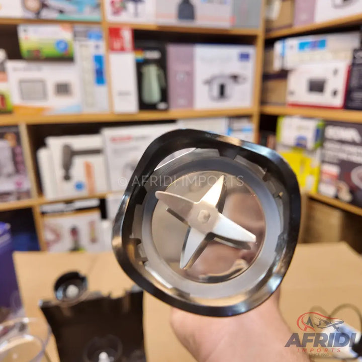 Handheld immersion blender with a four-pronged blade.