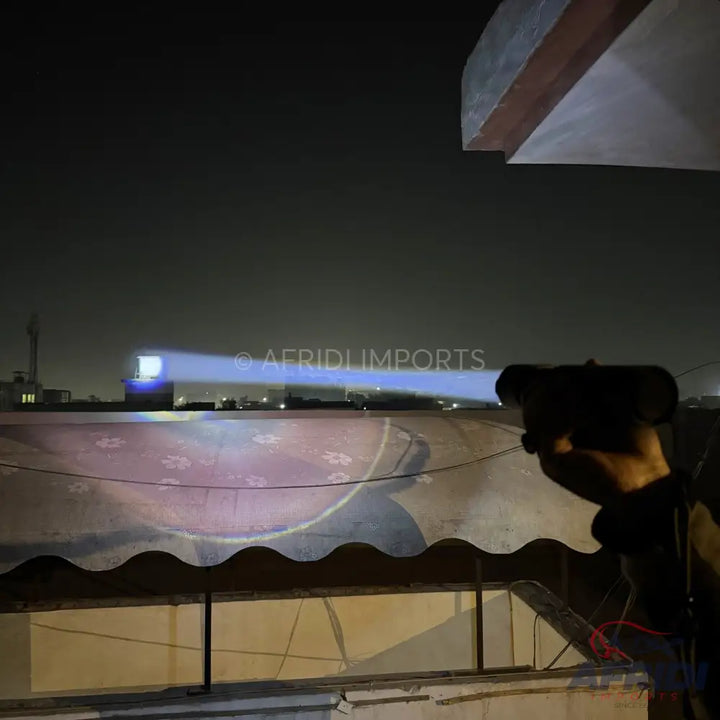 A handheld device emitting a bright blue beam of light with a projected pattern.