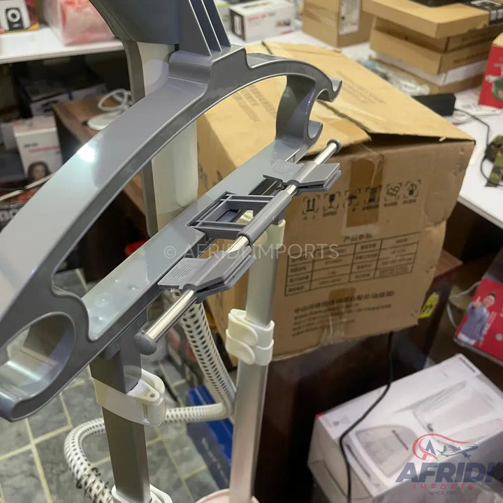 Gray garment steamer with a built-in hanger.