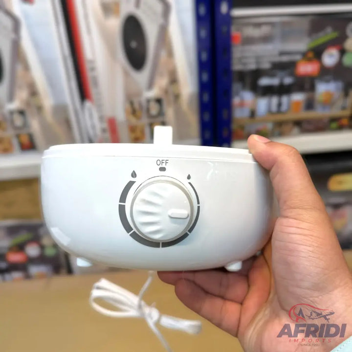 A white, portable humidifier or aroma diffuser with a single control dial for mist intensity and an ’OFF’ setting.