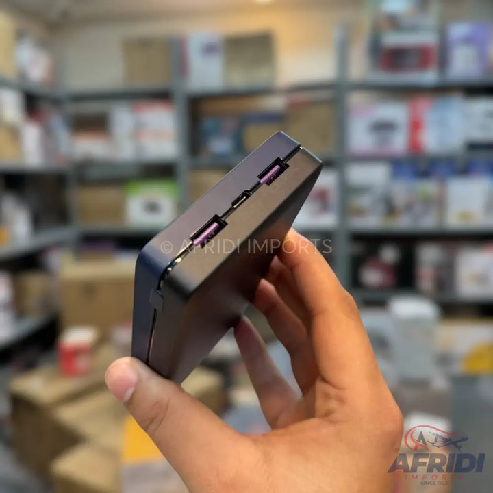A dark gray portable power bank with multiple USB ports.