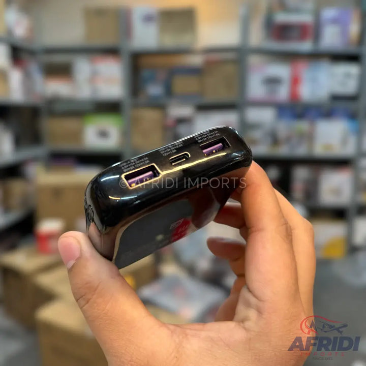 A black portable power bank with multiple USB and USB-C ports.