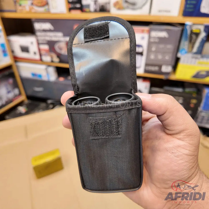 Black fabric case with two compartments, likely for holding small cylindrical objects, featuring a velcro closure on the flap and front.
