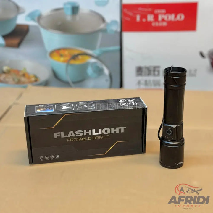 Black tactical flashlight with its packaging box.