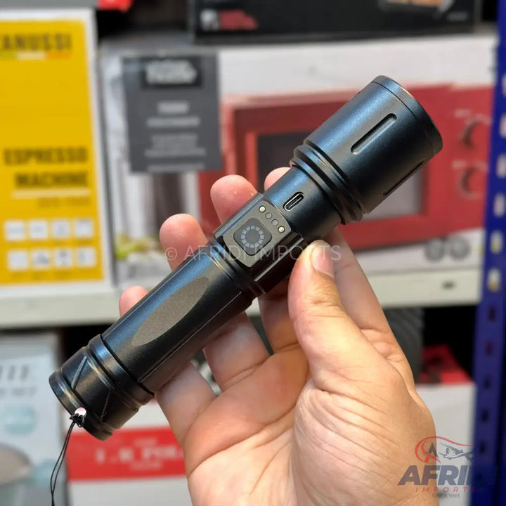 Black handheld flashlight with a side power button, battery indicator lights, and a USB-C charging port.