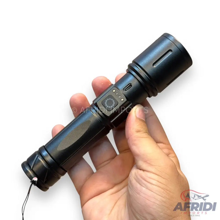 A black, handheld flashlight with a side-mounted power button, battery indicator lights, and a USB-C charging port.