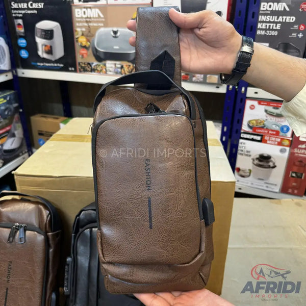 Brown faux leather sling bag with a USB charging port.