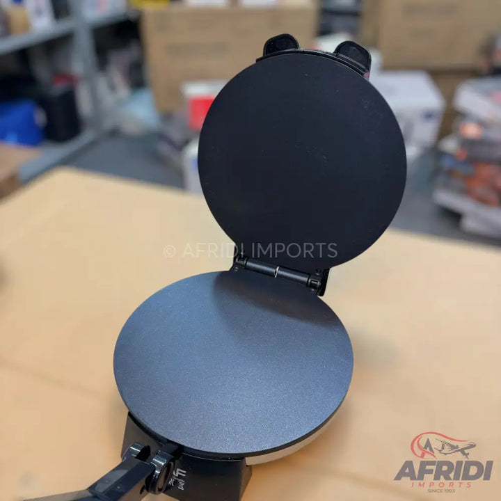 Open black non-stick tortilla or roti maker.