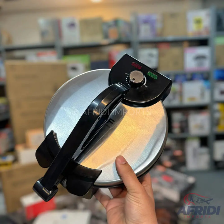 Round, silver and black electric tortilla or flatbread maker with a temperature dial.