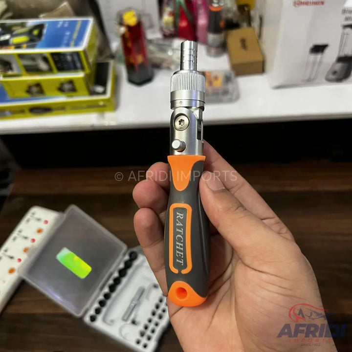 A multi-bit screwdriver with a gray and orange handle and a silver ratchet mechanism.