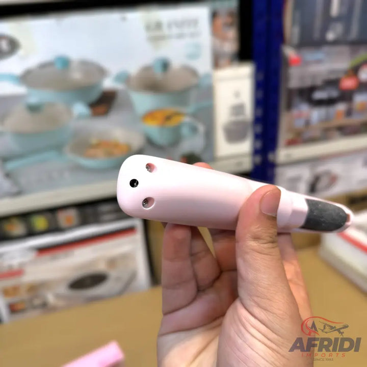 A person holding a pink electronic device with a dark tip and small circular openings.