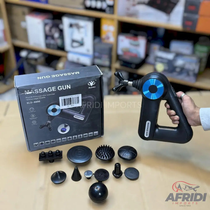 Black massage gun with multiple interchangeable head attachments and its packaging.