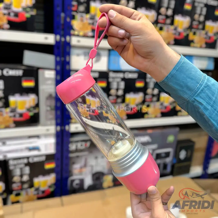 A clear portable blender with pink accents.