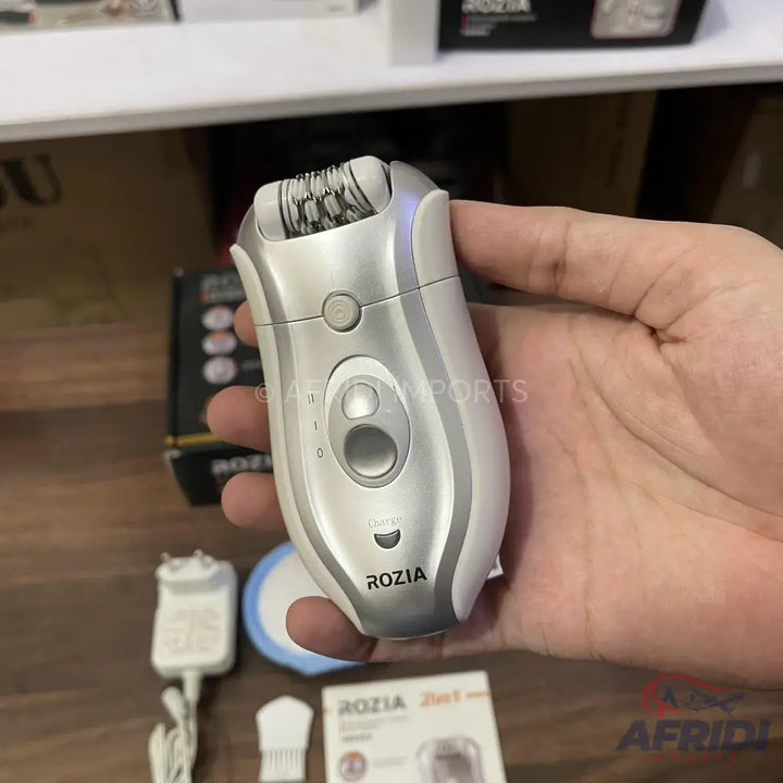 A silver and white electric epilator with multiple settings and a charging indicator.