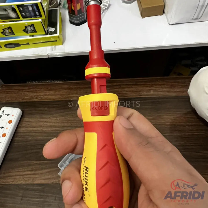 A red and yellow insulated screwdriver handle with a removable bit shaft, featuring a ’push to open’ mechanism.