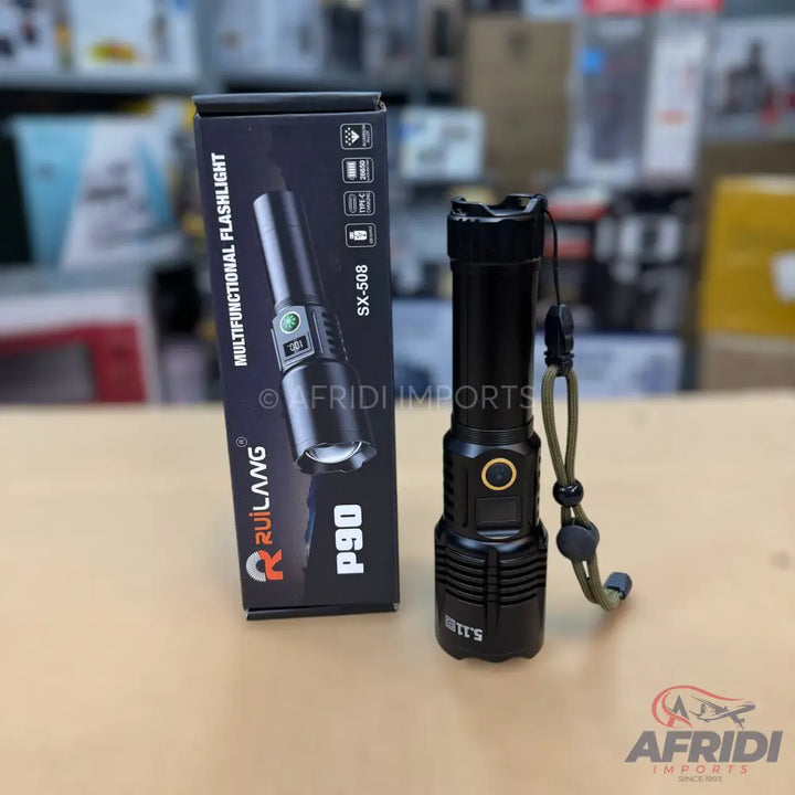 Black multifunctional flashlight with a lanyard, packaged in its box.