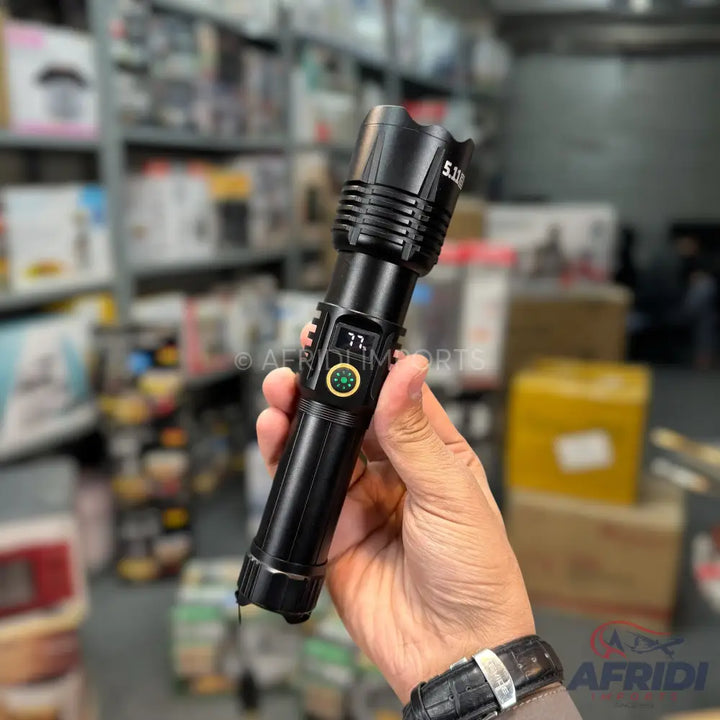 Black tactical flashlight with a digital display and built-in compass.