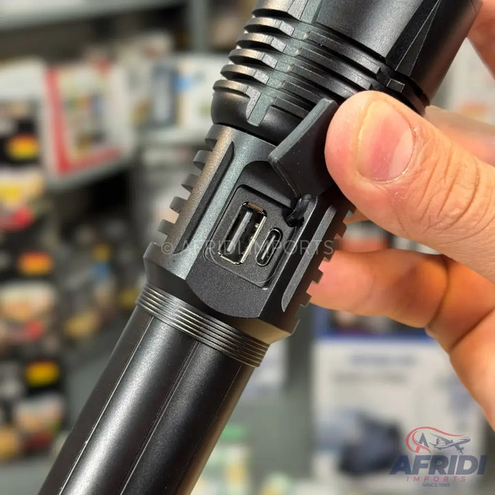 A black, rechargeable flashlight with USB-A and USB-C charging ports.