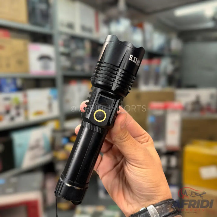 Black 5.11 Tactical flashlight with a yellow power button and digital display.