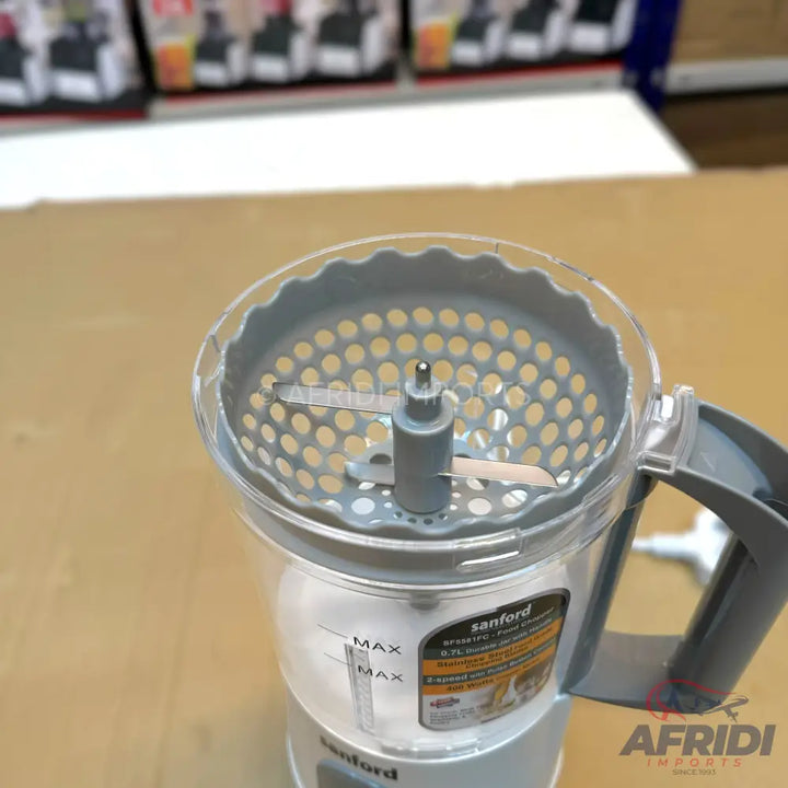 A clear plastic food processor with a gray handle, blade, and perforated insert.