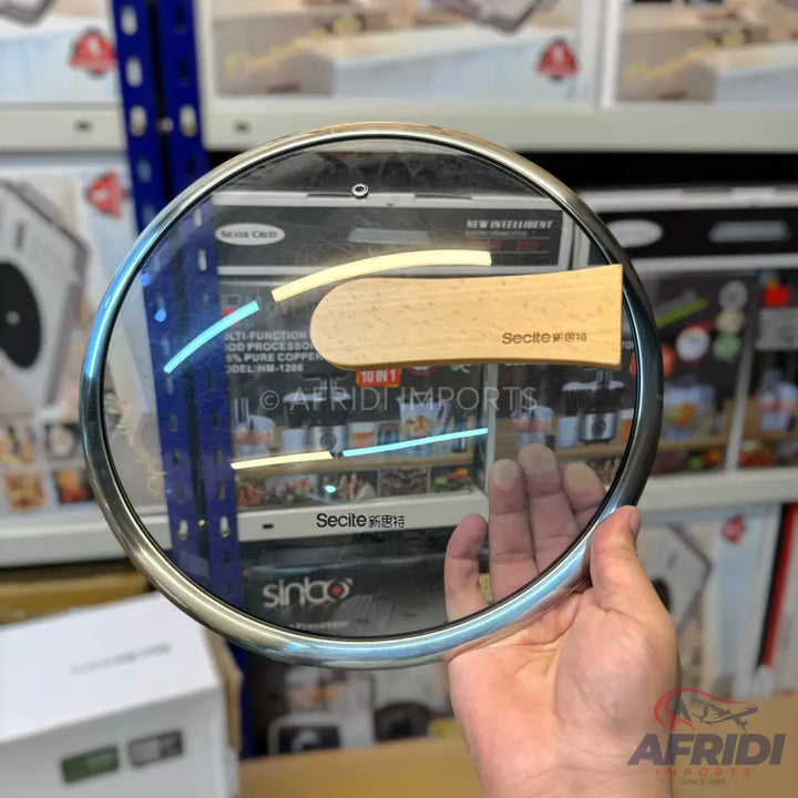 A glass lid with a wooden handle for cookware.