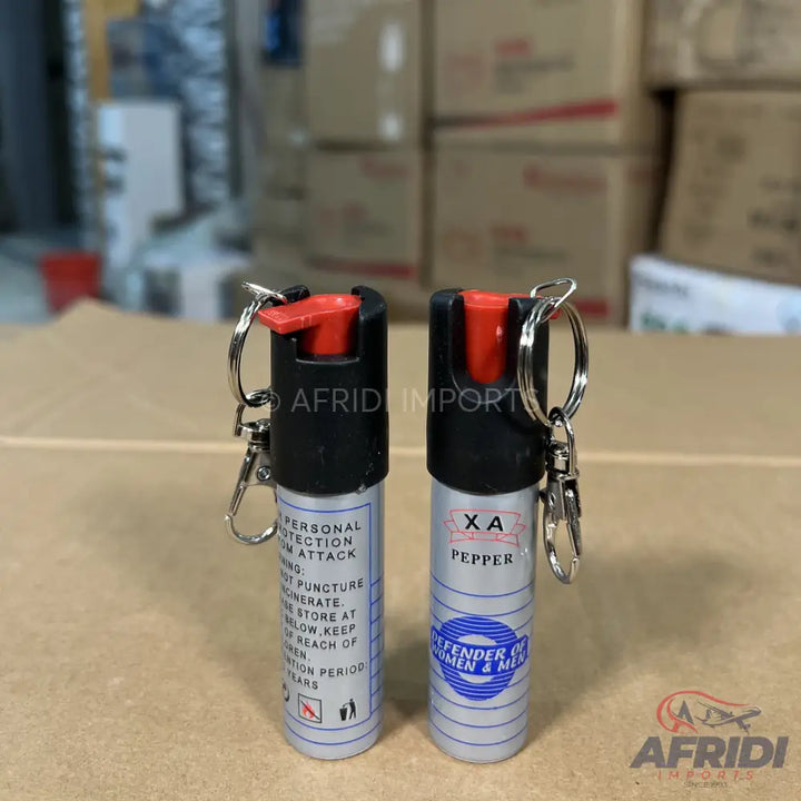 Two canisters of personal pepper spray with keychains.