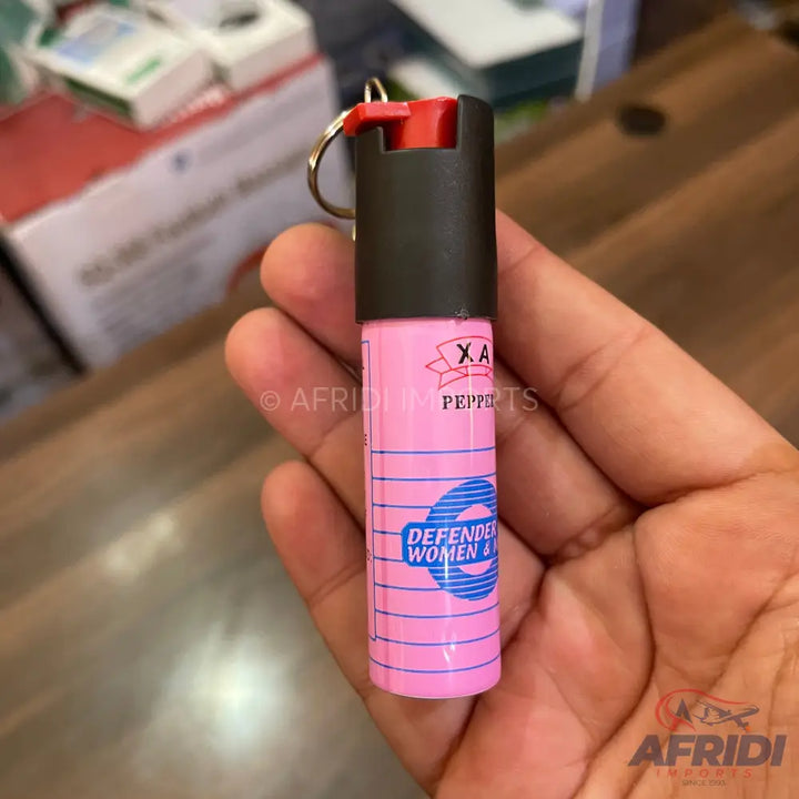 Pink keychain pepper spray with a black top and red nozzle.