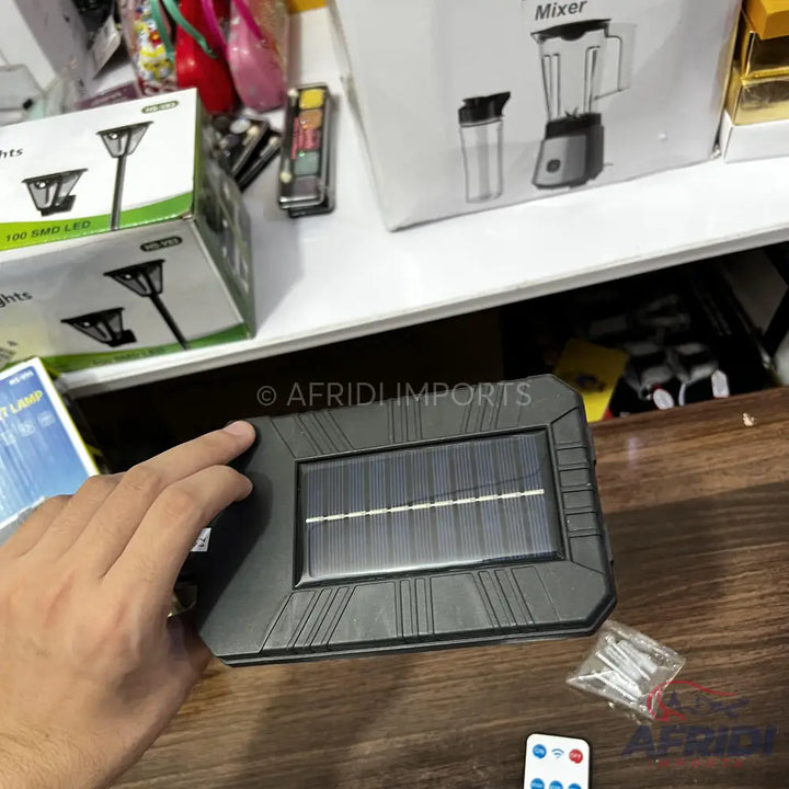 Black rectangular solar-powered light with a remote control.