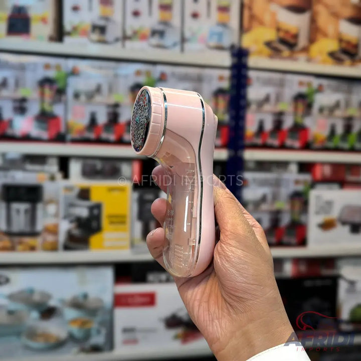 A pink and clear electric foot file with an abrasive roller head.